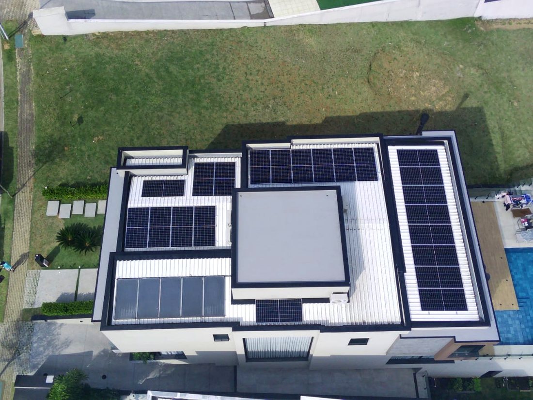 Sistema fotovoltaico em telhado residencial visto por drone